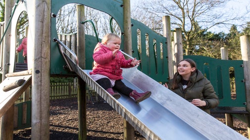 A family playing on the slide in the play area at Speke Hall, Liverpool
